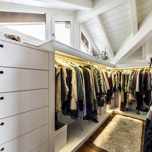 Foto di una grande cabina armadio unisex chic con nessun'anta, ante bianche, pavimento in legno massello medio e pavimento marrone