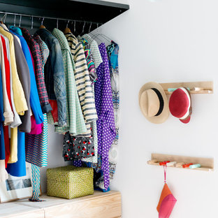 Immagine di una piccola cabina armadio unisex industriale con nessun'anta, pavimento in cemento, pavimento grigio e ante in legno chiaro