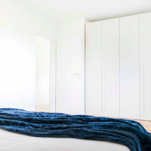 Modelo de armario y vestidor moderno, de tamaño medio, con armarios con paneles lisos y puertas de armario beige