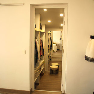 Esempio di una cabina armadio unisex minimal di medie dimensioni con ante con riquadro incassato, ante in legno chiaro e pavimento in legno massello medio