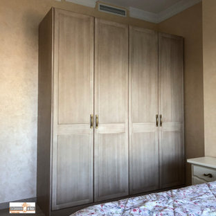 Ejemplo de armario y vestidor unisex, contemporáneo, de tamaño medio, con armarios con rebordes decorativos, puertas de armario de madera oscura, suelo de baldosas de cerámica y suelo beige