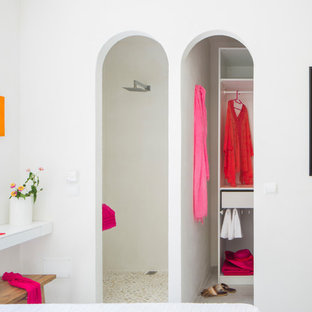 Esempio di una cabina armadio mediterranea di medie dimensioni con pavimento con piastrelle in ceramica, pavimento bianco, nessun'anta e ante bianche
