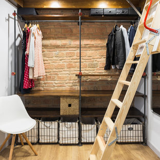 Idee per una piccola cabina armadio unisex industriale con nessun'anta, ante in legno bruno e parquet chiaro