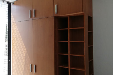 Imagen de armario y vestidor actual con puertas de armario de madera oscura