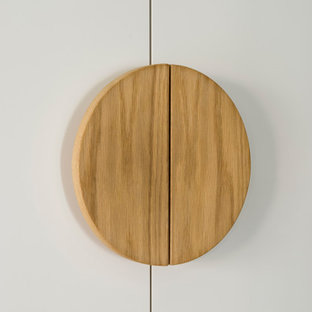Foto de armario y vestidor unisex, escandinavo, de tamaño medio, con armarios con paneles lisos, puertas de armario blancas, suelo de madera en tonos medios y suelo marrón