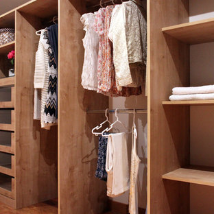 Esempio di un grande spazio per vestirsi per donna shabby-chic style con ante in legno chiaro e pavimento in legno massello medio