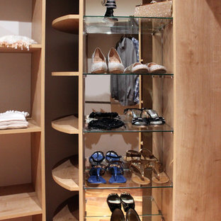 Immagine di un grande spazio per vestirsi per donna shabby-chic style con ante in legno chiaro e pavimento in legno massello medio