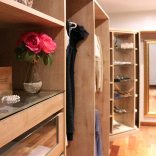 Immagine di un grande spazio per vestirsi per donna stile shabby con ante in legno chiaro e pavimento in legno massello medio