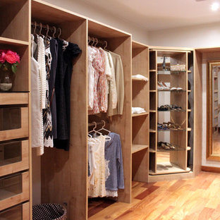 Idee per un grande spazio per vestirsi per donna shabby-chic style con ante in legno chiaro e pavimento in legno massello medio