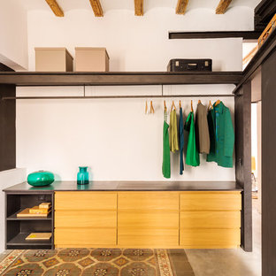 Foto di una cabina armadio unisex minimal di medie dimensioni con nessun'anta, ante in legno scuro, pavimento in cemento e pavimento multicolore