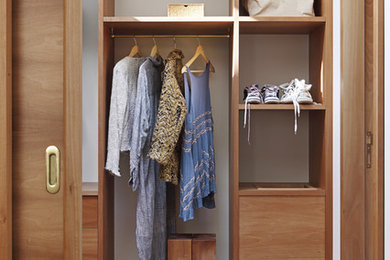 Foto de armario vestidor unisex tradicional renovado de tamaño medio con armarios abiertos, puertas de armario de madera oscura y suelo de madera clara
