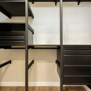 Esempio di una cabina armadio unisex industriale di medie dimensioni con ante lisce, ante bianche, pavimento in legno massello medio e pavimento marrone