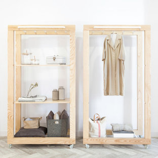 Immagine di un armadio o armadio a muro unisex industriale di medie dimensioni con nessun'anta, ante in legno chiaro, pavimento in gres porcellanato e pavimento grigio