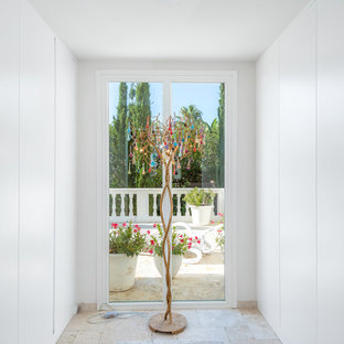 Ispirazione per una cabina armadio unisex mediterranea di medie dimensioni con ante lisce e ante bianche