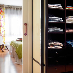 Foto de armario vestidor de hombre, clásico renovado, de tamaño medio, con armarios abiertos, puertas de armario negras y suelo de madera en tonos medios