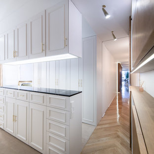 Ejemplo de vestidor unisex, contemporáneo, con armarios con paneles empotrados, puertas de armario blancas y suelo beige