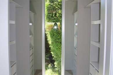 Diseño de vestidor unisex clásico renovado de tamaño medio con armarios abiertos, puertas de armario blancas y suelo de madera en tonos medios