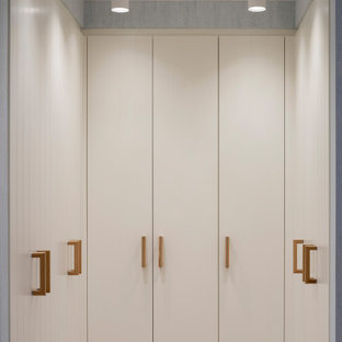 Idee per una cabina armadio unisex scandinava di medie dimensioni con ante lisce, ante bianche, pavimento in laminato e pavimento marrone