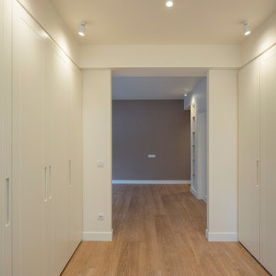 Imagen de armario vestidor unisex, clásico, grande, con armarios con paneles lisos, puertas de armario blancas, suelo laminado y suelo marrón
