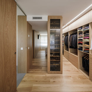Idee per una cabina armadio per uomo minimalista con ante in legno scuro, pavimento in legno massello medio, ante lisce e pavimento beige