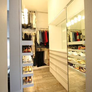 Diseño de armario vestidor de mujer, minimalista, grande, con armarios con paneles lisos, puertas de armario blancas, suelo de baldosas de porcelana y suelo gris