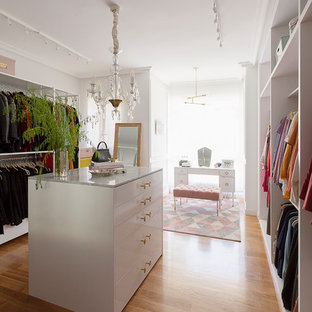 Ejemplo de vestidor de mujer, bohemio, grande, con armarios abiertos, suelo de madera en tonos medios y suelo beige
