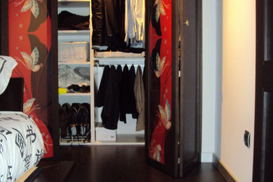 Diseño de armario vestidor unisex tropical pequeño con suelo de madera oscura