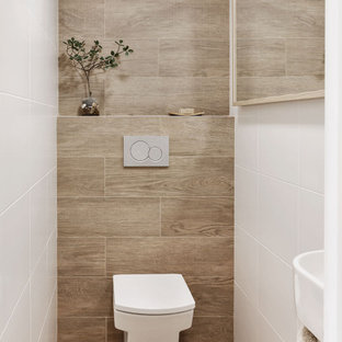Esempio di un piccolo bagno di servizio nordico con ante bianche, WC sospeso, piastrelle bianche, piastrelle in ceramica, pareti bianche, pavimento in gres porcellanato, lavabo sospeso, pavimento marrone e mobile bagno sospeso
