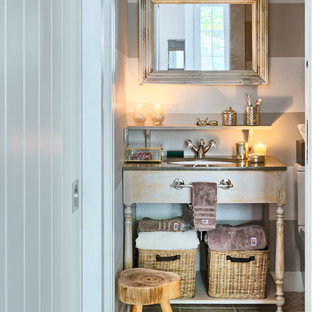 Esempio di un piccolo bagno di servizio nordico con consolle stile comò, ante in legno chiaro, pareti multicolore, pavimento in terracotta, lavabo sottopiano e top in superficie solida