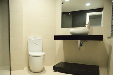 Imagen de aseo tradicional renovado pequeño con armarios abiertos, sanitario de dos piezas, paredes beige y lavabo sobreencimera