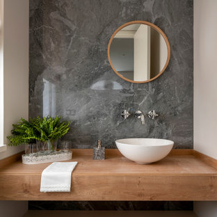 Imagen de aseo escandinavo, de tamaño medio, con armarios abiertos, puertas de armario de madera oscura, baldosas y/o azulejos grises, baldosas y/o azulejos de porcelana, lavabo sobreencimera, encimera de madera, encimeras marrones y paredes blancas