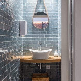 Foto di un piccolo bagno di servizio nordico con pareti blu, pavimento in legno massello medio, lavabo a bacinella, top in legno, piastrelle blu, piastrelle in ceramica e top marrone