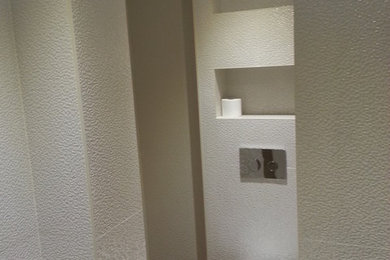 Imagen de aseo clásico renovado pequeño con sanitario de pared y suelo de madera oscura