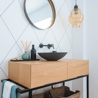 Imagen de aseo contemporáneo con armarios con paneles lisos, puertas de armario de madera oscura, baldosas y/o azulejos blancos, paredes blancas, suelo de madera en tonos medios, lavabo sobreencimera, encimera de madera, suelo marrón y encimeras marrones