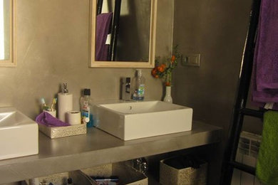 マドリードにある低価格の小さなトランジショナルスタイルのおしゃれなトイレ・洗面所 (オープンシェルフ、グレーのキャビネット、ベッセル式洗面器) の写真