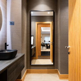 Ispirazione per un bagno di servizio contemporaneo con ante lisce, ante grigie, pareti grigie, lavabo a bacinella, top in legno, pavimento beige e top grigio