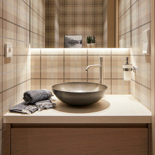 Ejemplo de aseo actual con armarios con paneles lisos, puertas de armario de madera clara, paredes multicolor, lavabo sobreencimera, suelo beige y encimeras beige