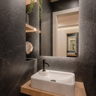 Ejemplo de aseo flotante, contemporáneo, pequeño, con puertas de armario de madera clara, baldosas y/o azulejos grises, lavabo sobreencimera y encimeras beige