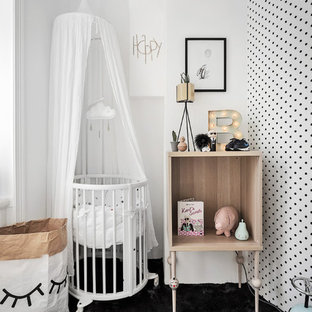 Imagen de habitación de bebé neutra nórdica, de tamaño medio, con paredes negras y moqueta