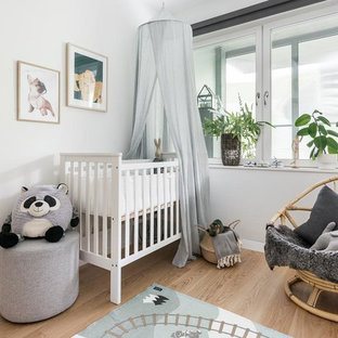 Foto på ett nordiskt könsneutralt babyrum, med vita väggar och ljust trägolv