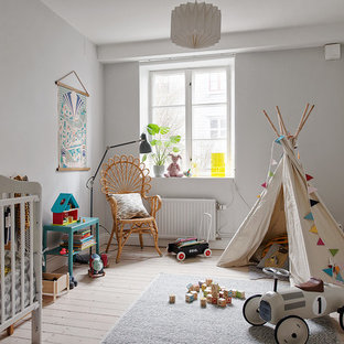 Foto de habitación de bebé neutra nórdica, de tamaño medio, con paredes grises, suelo de madera clara y suelo beige