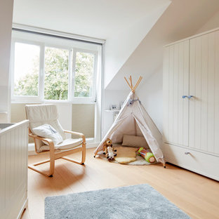 Mittelgroßes Skandinavisches Babyzimmer mit weißer Wandfarbe, hellem Holzboden und beigem Boden in Bremen