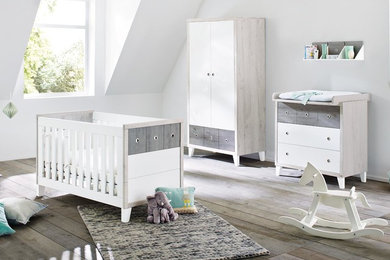 Neutrales Modernes Babyzimmer mit weißer Wandfarbe und braunem Holzboden in Hamburg