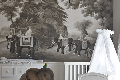 Ejemplo de habitación de bebé neutra exótica de tamaño medio con suelo de madera en tonos medios y paredes grises