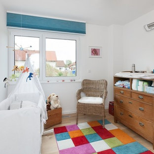 Kleines Modernes Babyzimmer mit weißer Wandfarbe, hellem Holzboden und beigem Boden in Stuttgart