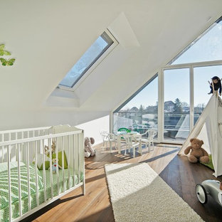 Neutrales, Mittelgroßes Modernes Babyzimmer mit weißer Wandfarbe, braunem Holzboden und braunem Boden in München