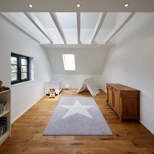 Mittelgroßes, Neutrales Country Babyzimmer mit weißer Wandfarbe, braunem Holzboden und braunem Boden in Köln