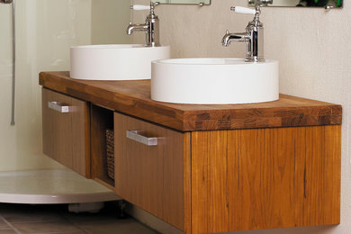 Diseño de cuarto de baño principal escandinavo de tamaño medio con armarios tipo mueble, puertas de armario de madera en tonos medios, paredes blancas, lavabo sobreencimera y encimera de madera