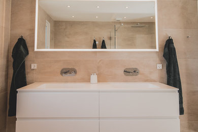 Idéer för ett stort modernt vit badrum med dusch, med släta luckor, vita skåp, en toalettstol med hel cisternkåpa, beige kakel, keramikplattor, beige väggar, klinkergolv i keramik, ett integrerad handfat, beiget golv och dusch med skjutdörr
