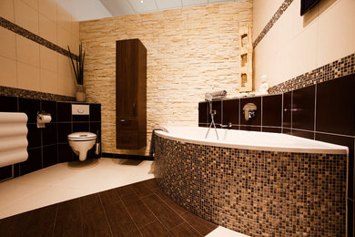 Diseño de cuarto de baño de estilo zen de tamaño medio con armarios con paneles lisos, puertas de armario de madera en tonos medios, bañera esquinera, sanitario de pared, baldosas y/o azulejos beige, baldosas y/o azulejos de cerámica, suelo de baldosas de cerámica y suelo marrón